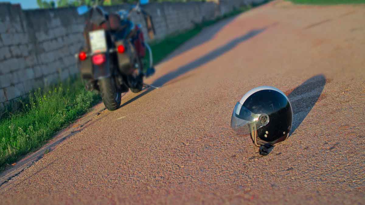 Why do some riders place their helmet on the ground behind their motorcycle?