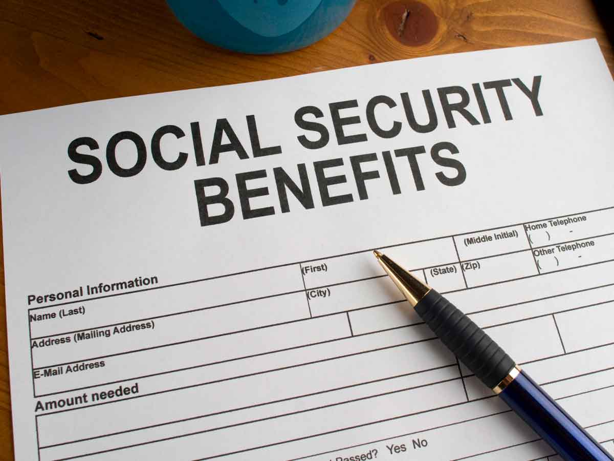 Social Security benefits application form with pen on wooden desk