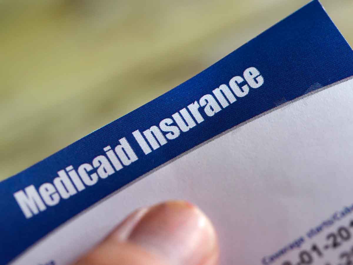 Medicaid Insurance form held in hand, illustrating a senior’s loss of coverage after Social Security income exceeds eligibility limits