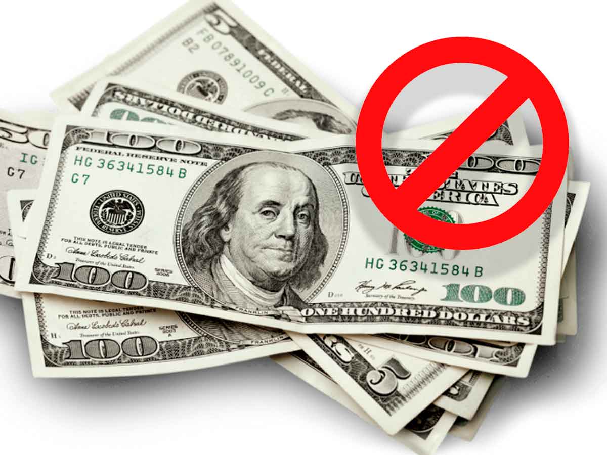 Stack of U.S. $100 bills with a bold red prohibition symbol, illustrating CIS countries banning dollar transactions in 2025