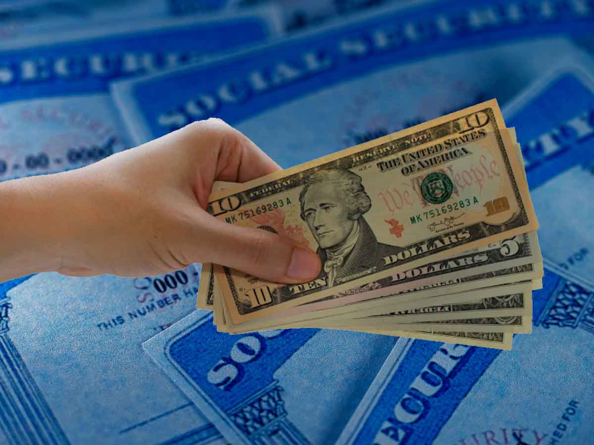 Hand holding U S dollars over Social Security cards, symbolizing two May payments—$1,450 SSI and $2,000 retirement benefit
