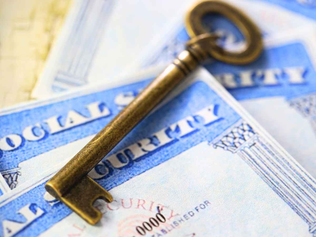 Old key resting on Social Security cards, symbolizing access to retirement and financial aid programs