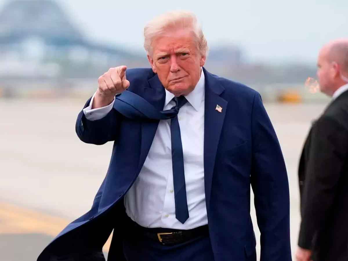 Government official in navy suit points on airport tarmac after revoking CBP One migrant permits