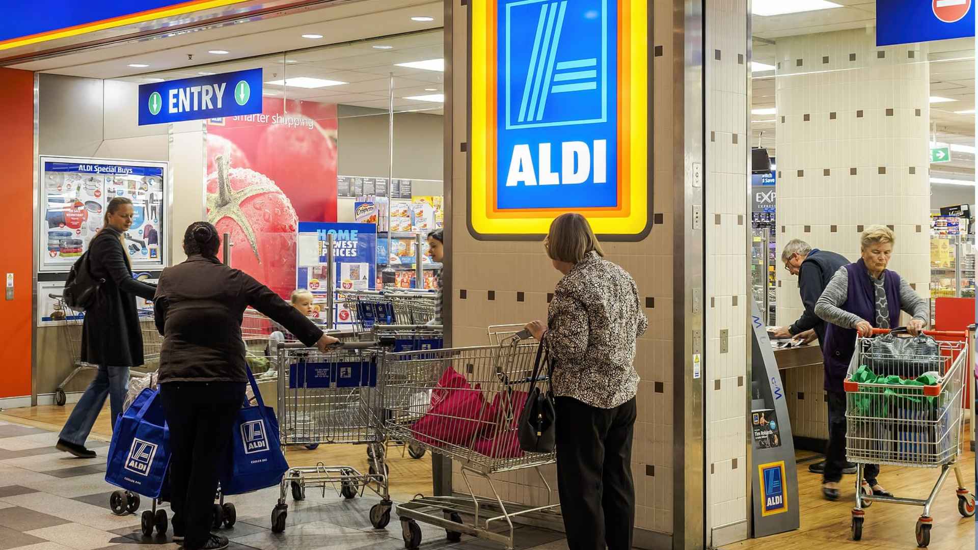 Customers push carts into Aldi’s Greenwich pilot store, where a €12 entry deposit and smart sensors replace traditional checkout lines.