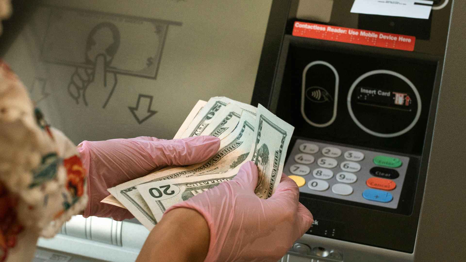 Customer counting cash at a Bank of America ATM machine