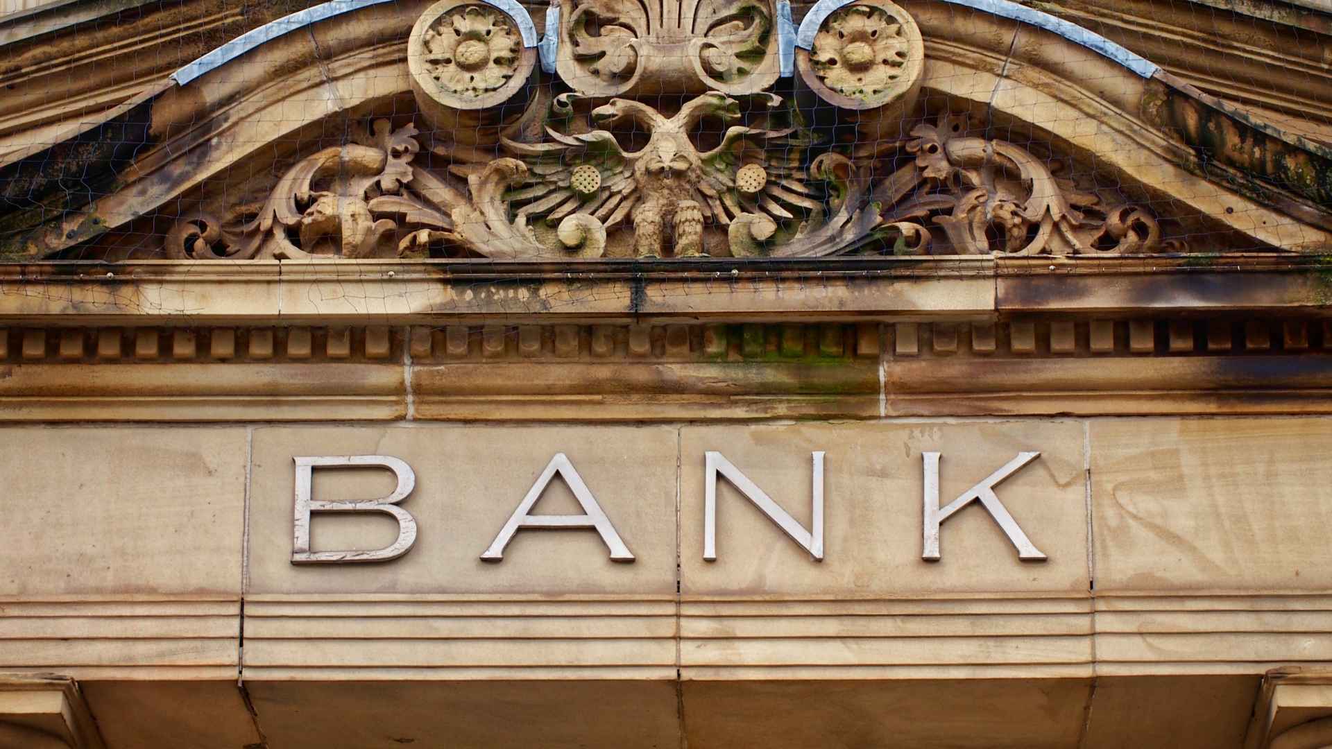 Historic stone bank façade with large “BANK” lettering, illustrating TD Bank’s June 5 closure of 38 branches nationwide.
