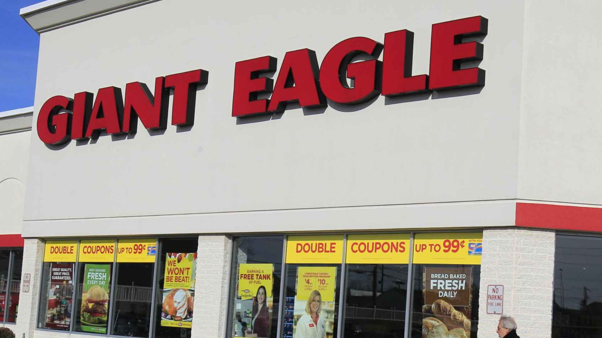 Exterior of Giant Eagle supermarket at Parkway Center in Pittsburgh with a senior shopper pushing a cart before store closure.