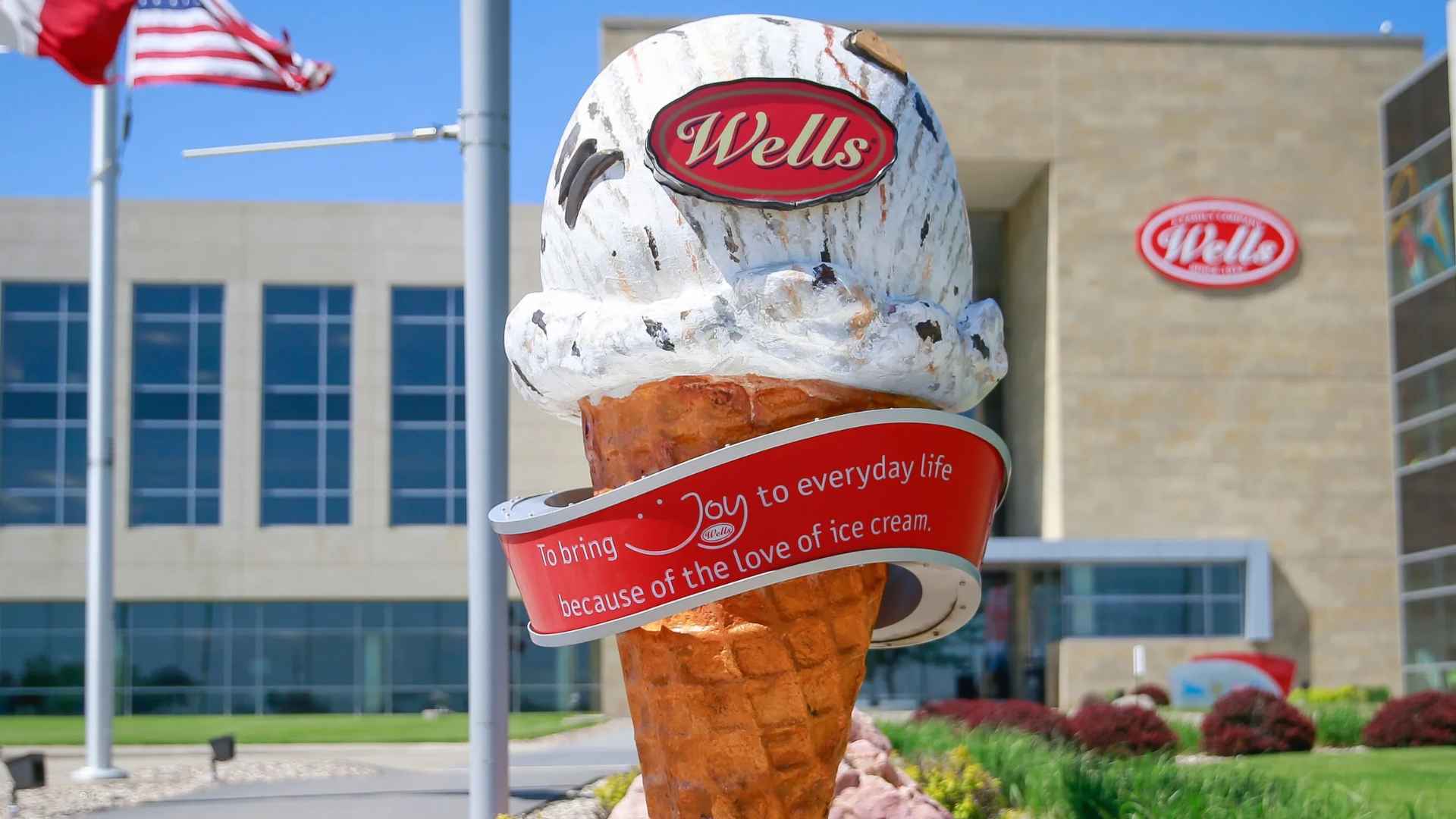 Wells Enterprises headquarters in Le Mars, Iowa, with giant ice-cream-cone sculpture and company logo in foreground.