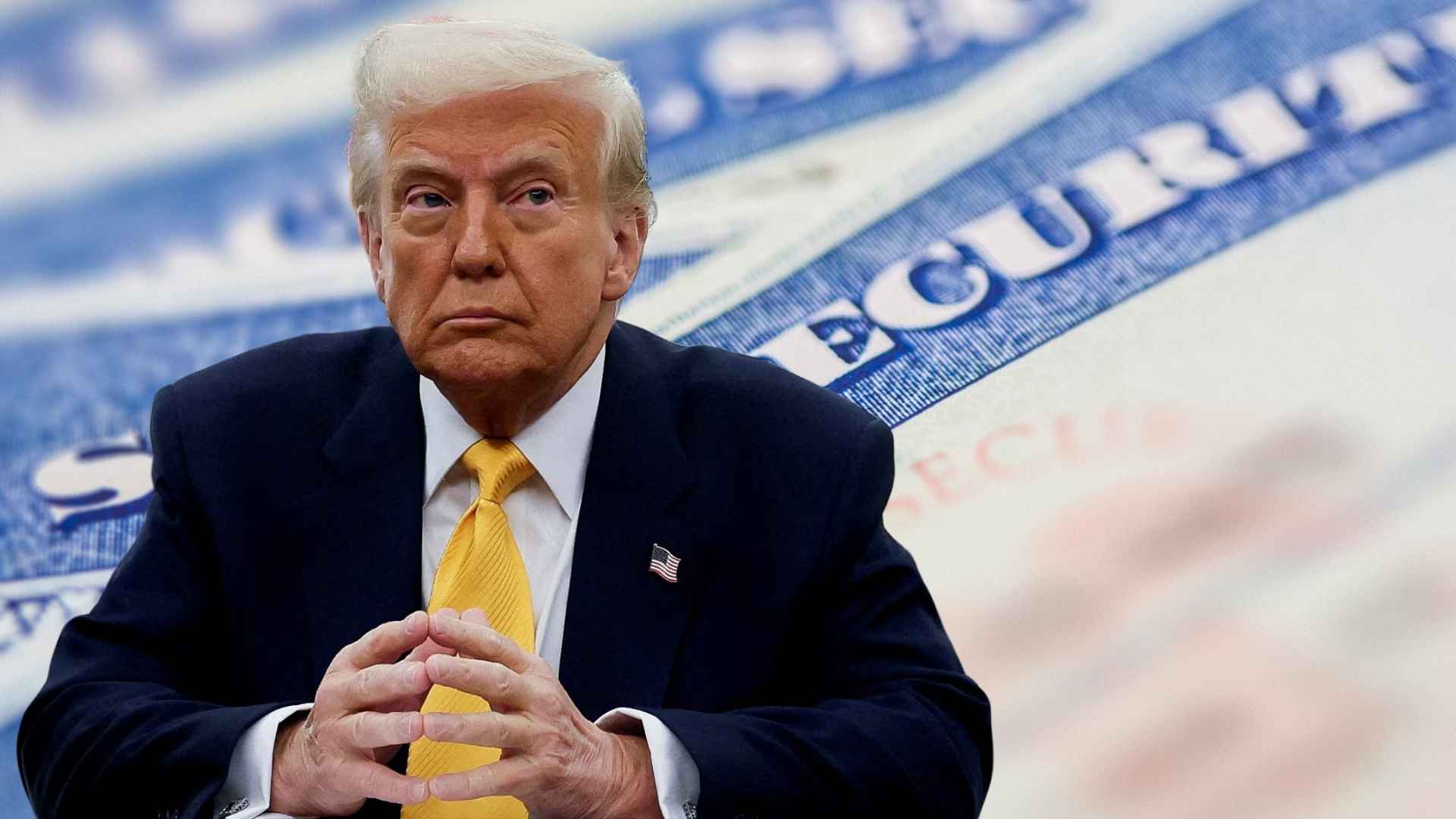 Businessman in navy suit and yellow tie seated before blurred Social Security card, illustrating retirement-benefit news