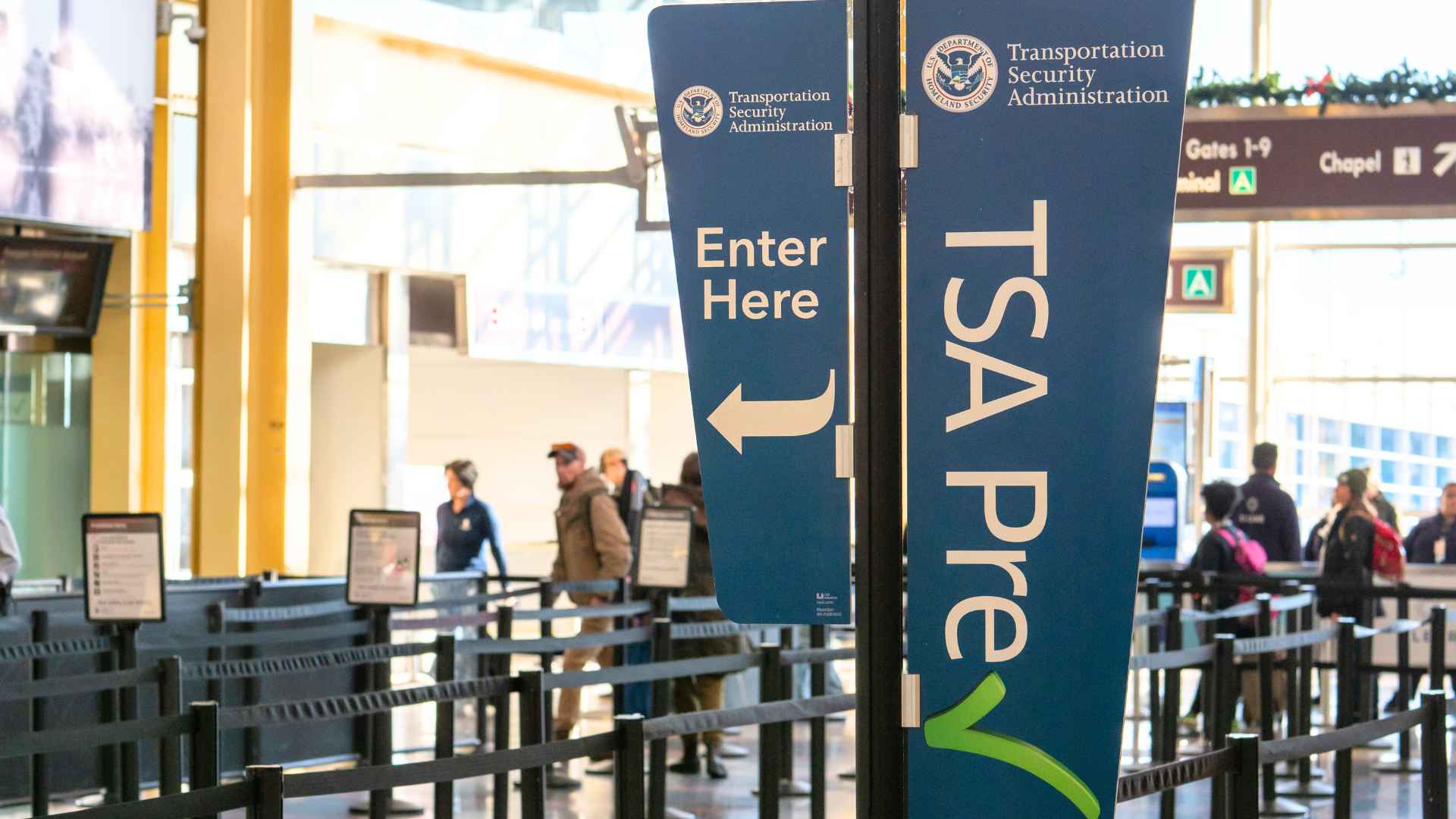 TSA Pre security checkpoint at a U.S. airport, highlighting new baggage rules that keep lithium-battery devices out of checked bags.