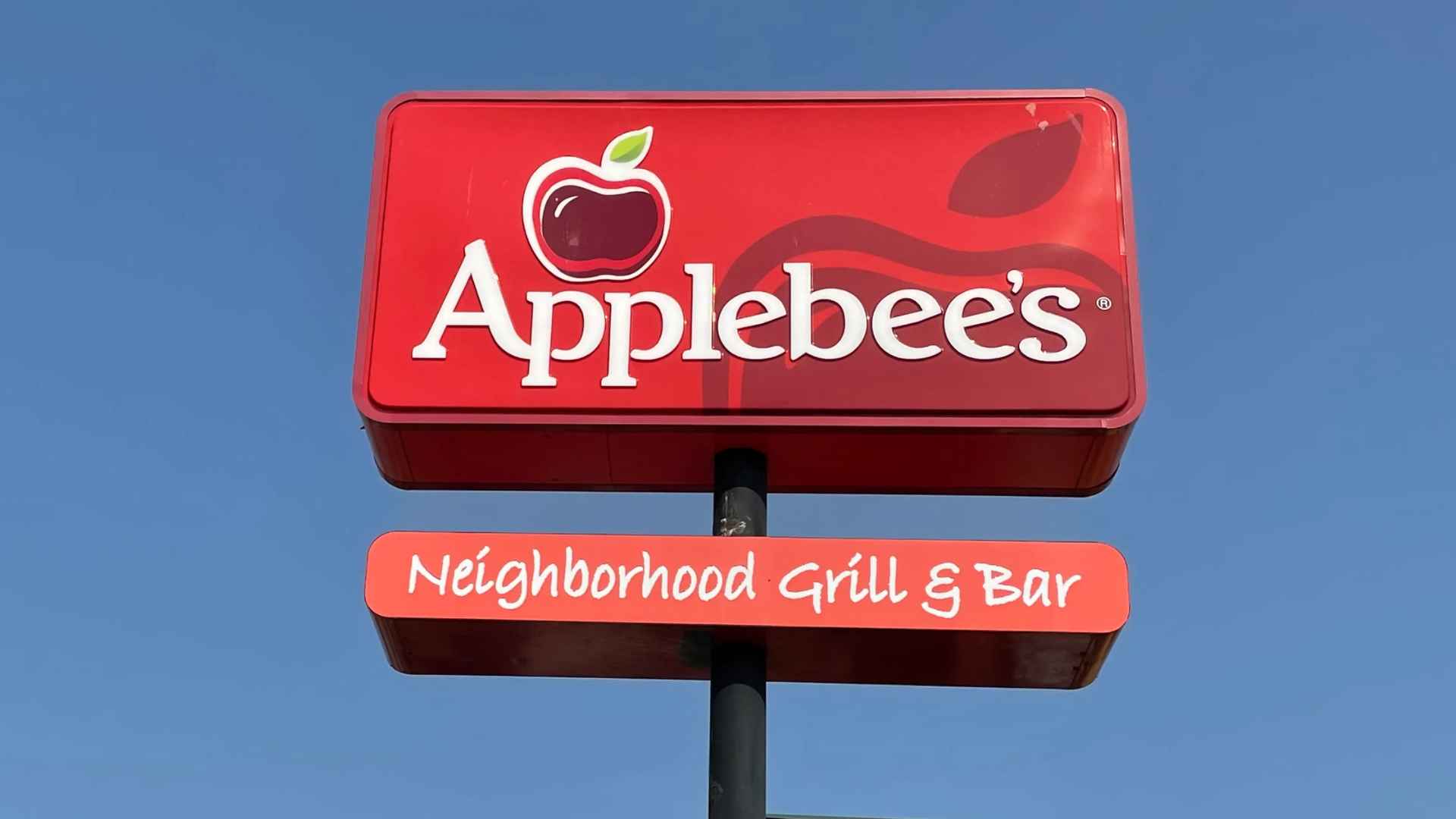 Applebee’s restaurant sign against a clear blue sky; chain now faces a class-action lawsuit over online-order junk fees
