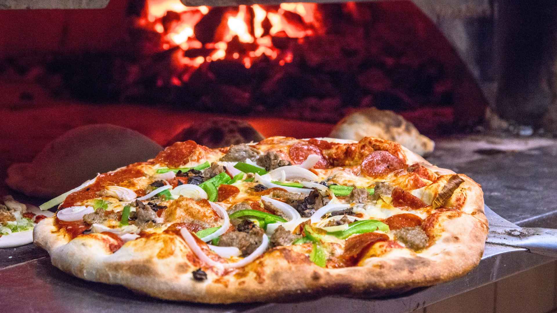 Rustic Crust pepperoni-and-veggie pizza sliding from a wood-fired oven at the Pittsfield plant before its sudden closure