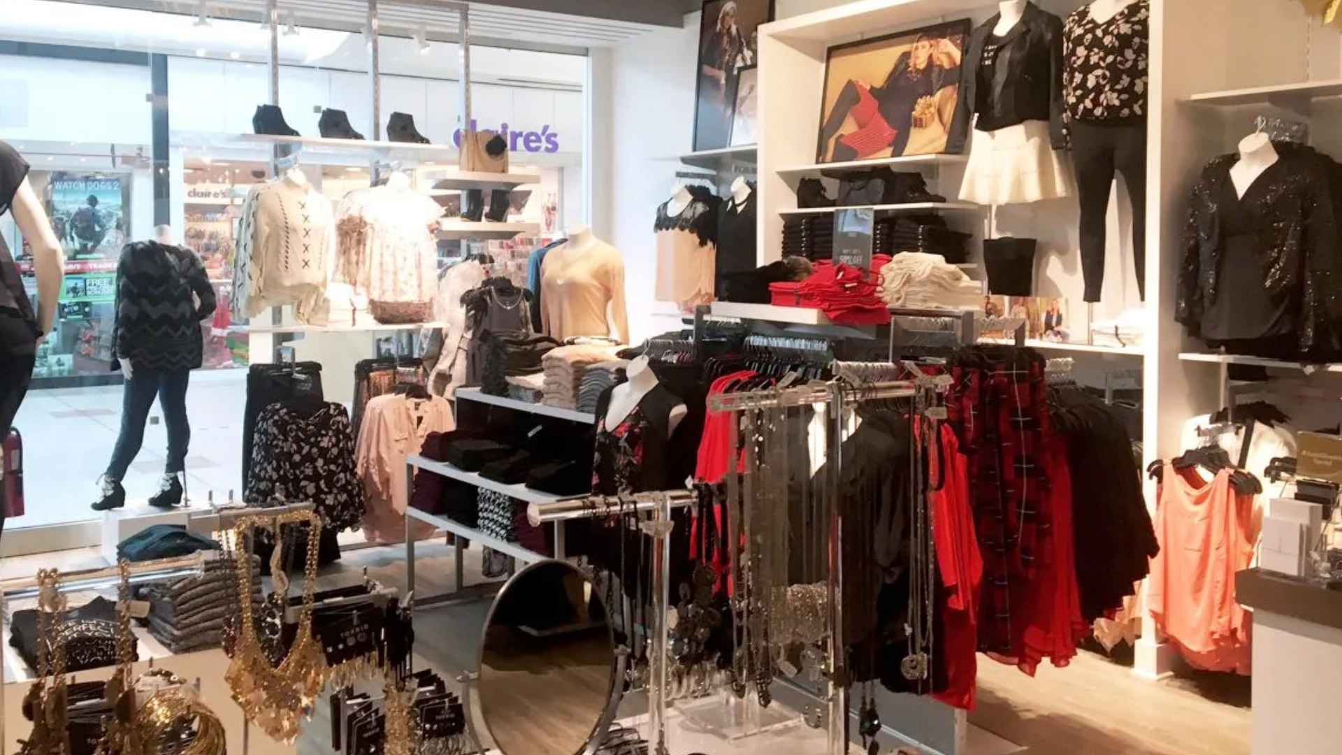 Interior of a Torrid women’s clothing store filled with racks of apparel, accessories, and mannequins; retailer plans to close 180 locations by 2025.