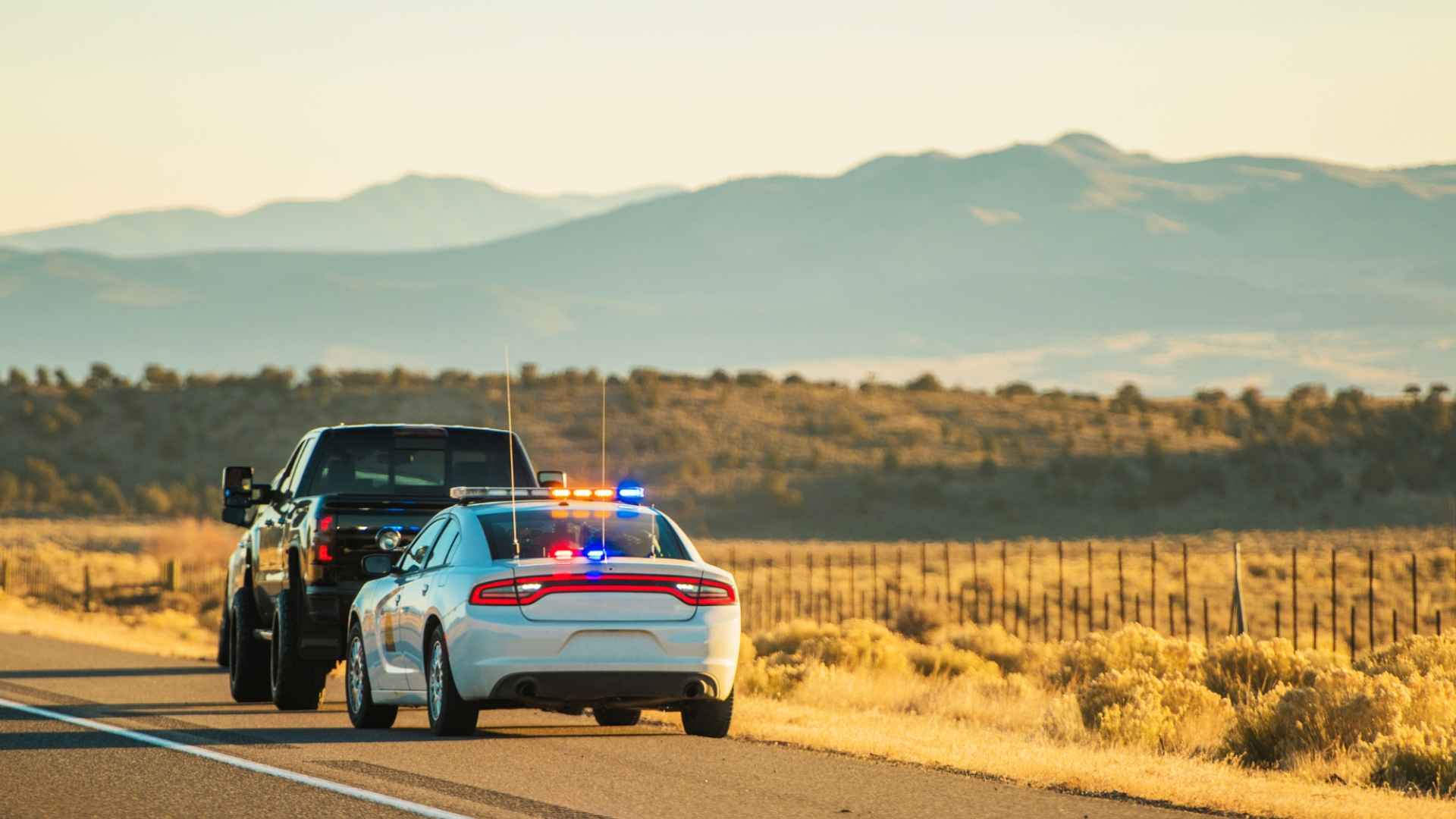 Florida Highway Patrol cruiser pulls over a speeding pickup on a rural highway ahead of July 2025 $500 super-speed law.