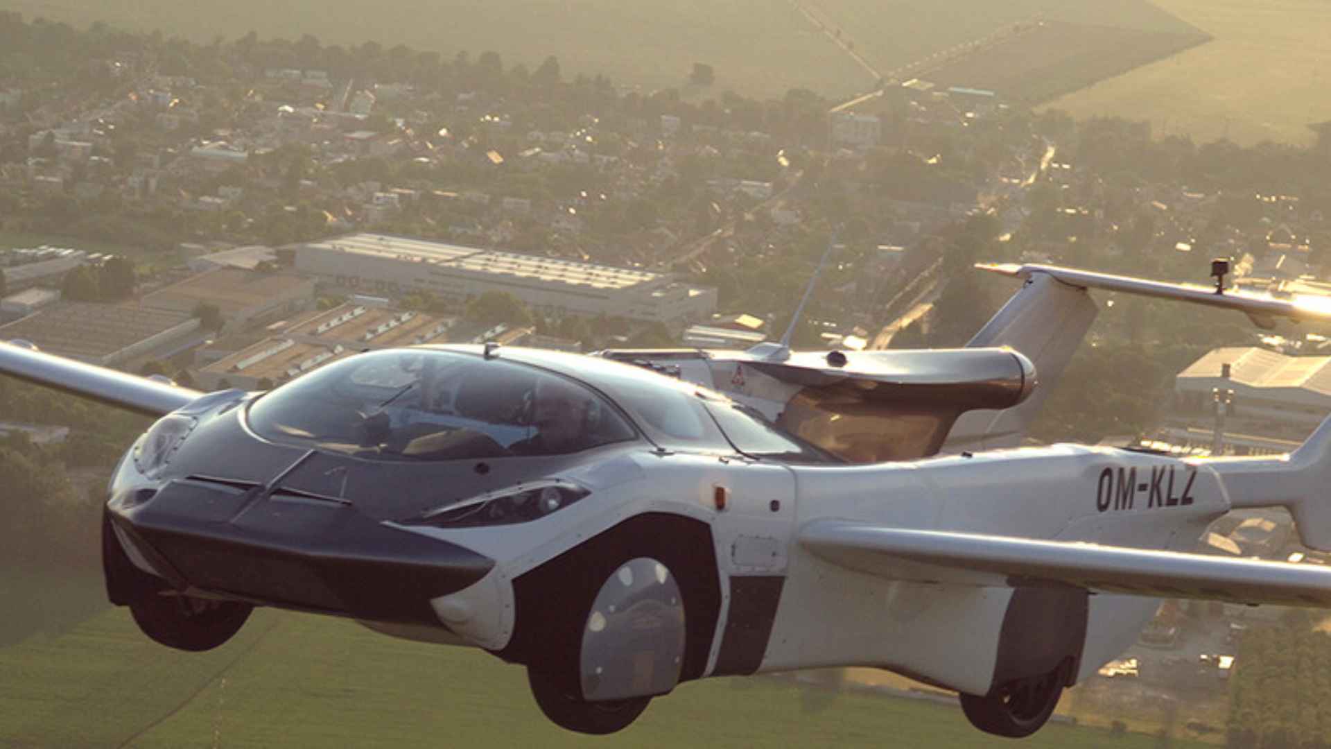 AirCar flying car prototype OM-KLZ cruising above countryside, illustrating the personal road-and-air vehicle slated for a 2026 U.S. debut