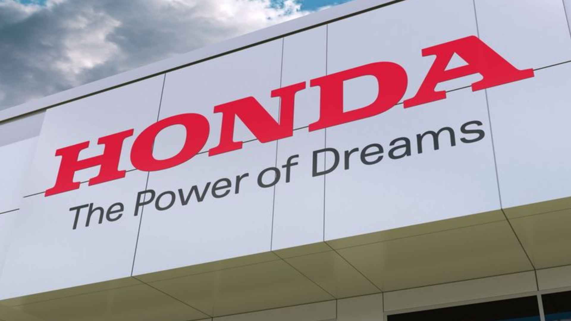 Facade of Honda headquarters in Japan with red Honda logo and “Power of Dreams” slogan amid Civic Type R production halt announcement