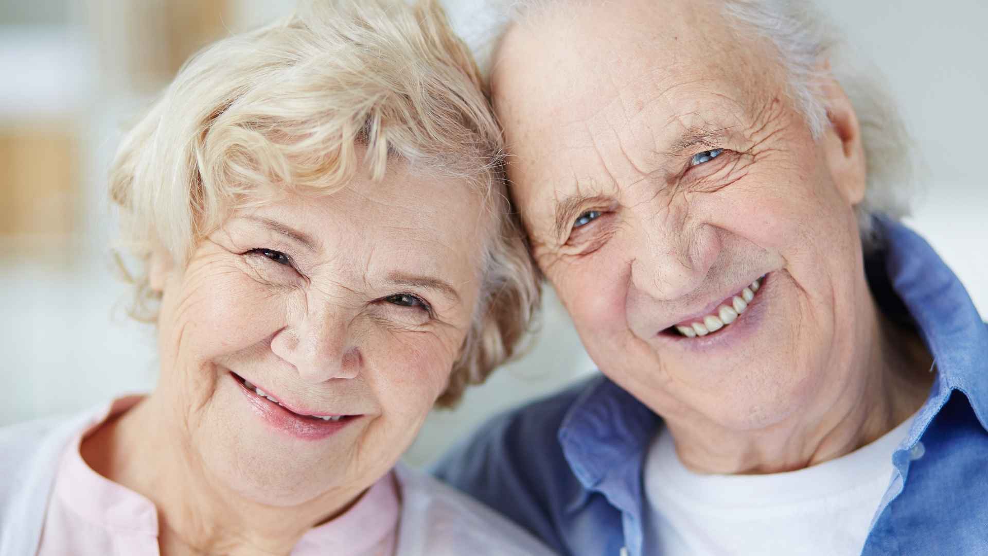 Smiling elderly couple embracing at home, representing retirees living on Social Security income and managing expenses