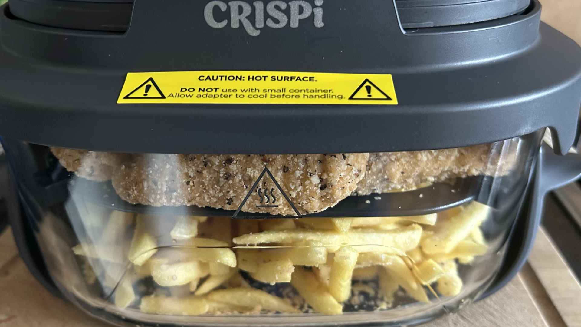 Ninja Crispi portable glass air fryer frying chicken cutlets and French fries together in a single container