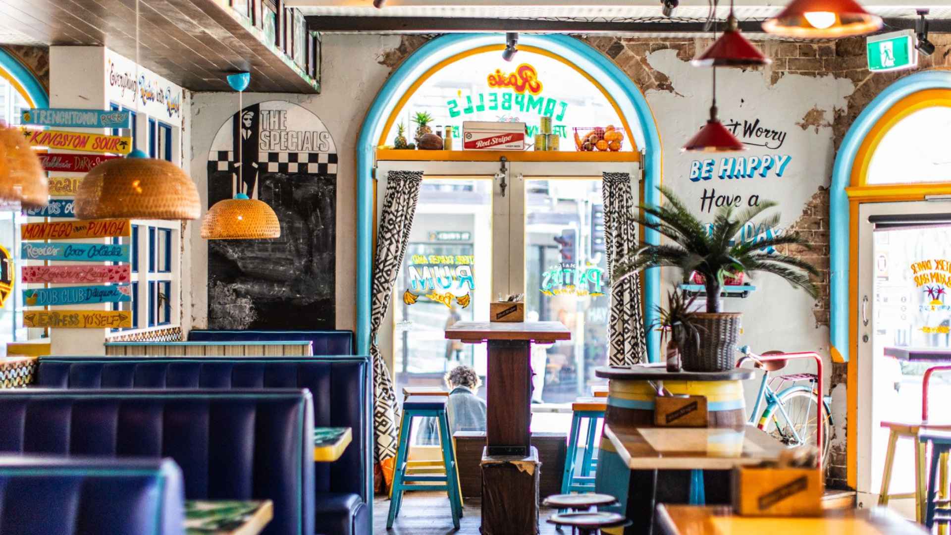 Rosie’s Cafe interior in Sioux Falls with blue vinyl booths, wicker pendant lamps and retro signs, photographed days before permanent closure.