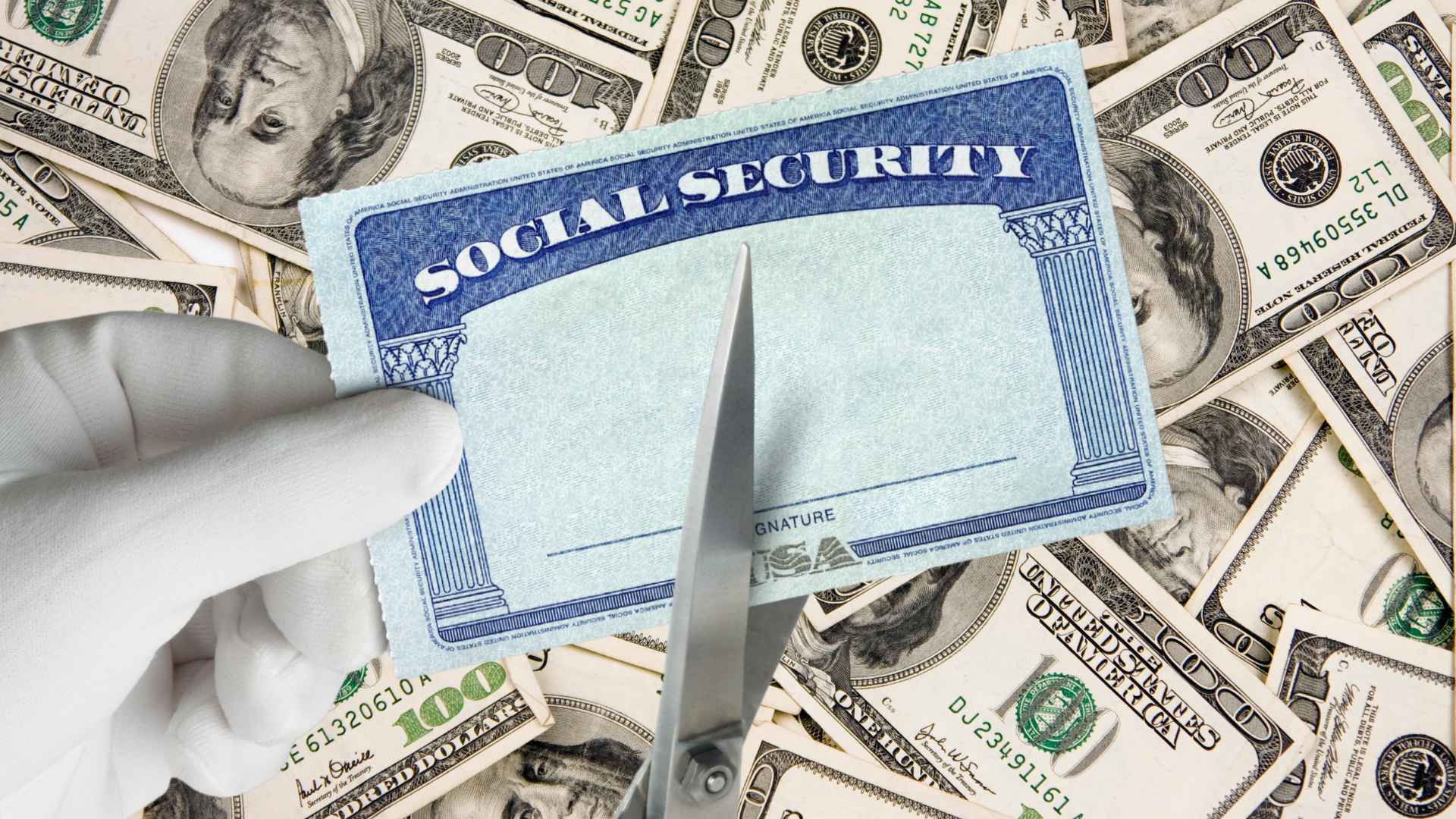Scissors cutting Social Security card over a pile of money, symbolizing benefit reductions and retirement age changes
