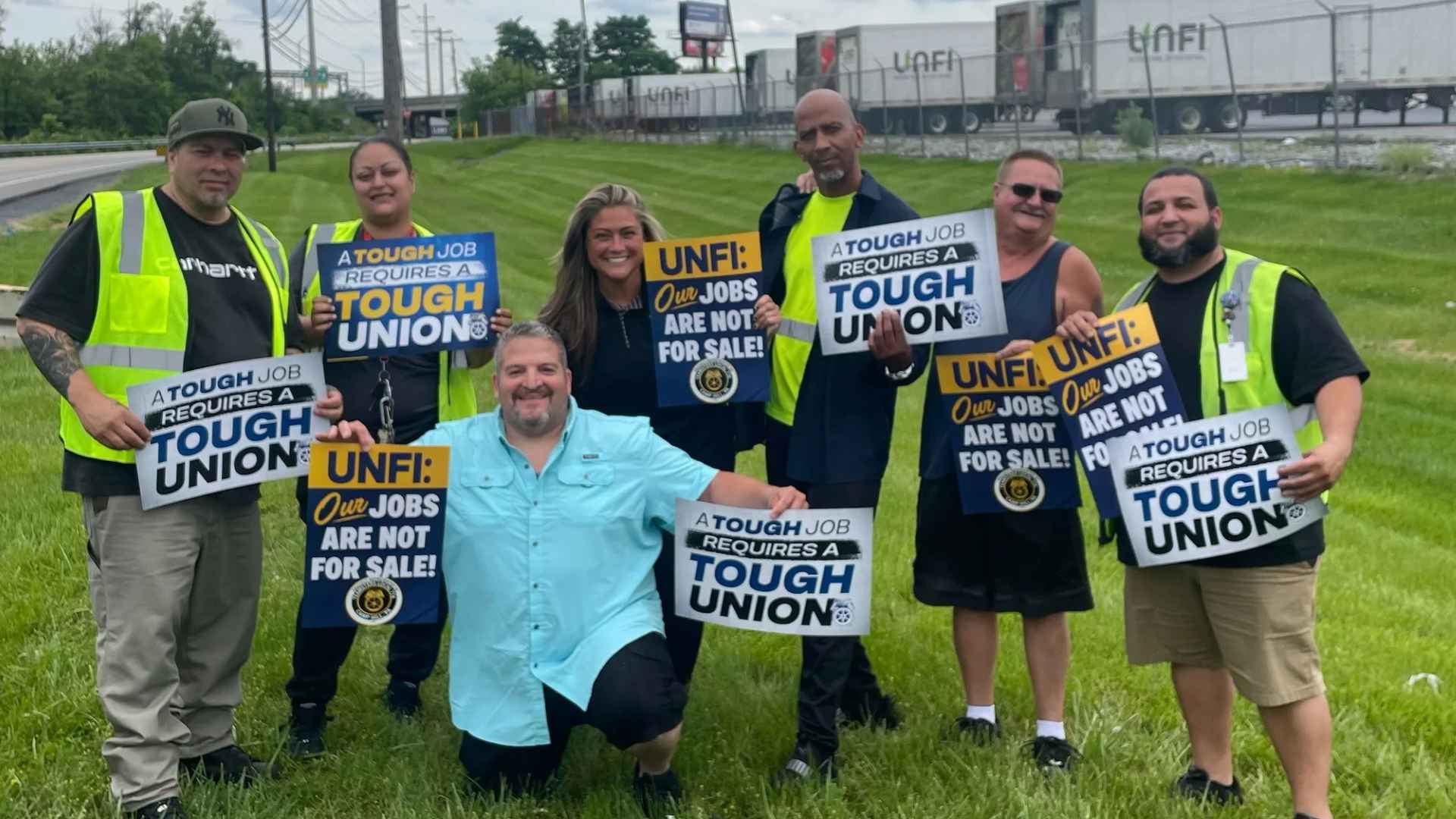 Workers outside UNFI facility holding union signs protesting layoffs linked to Key Food contract termination