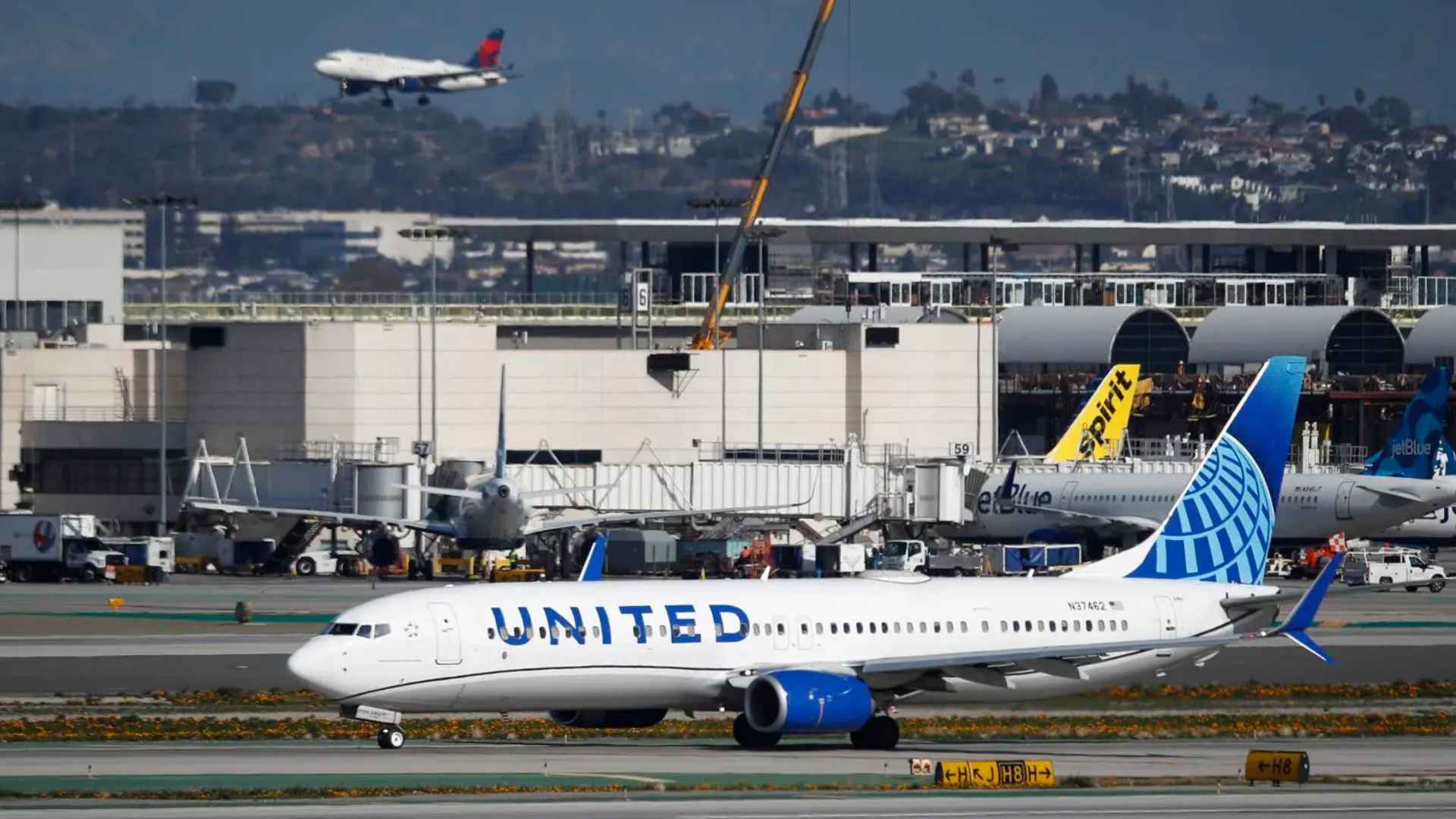 United Airlines Boeing 737 taxiing at a busy U.S. airport ahead of the new 45-minute carry-on check-in deadline.
