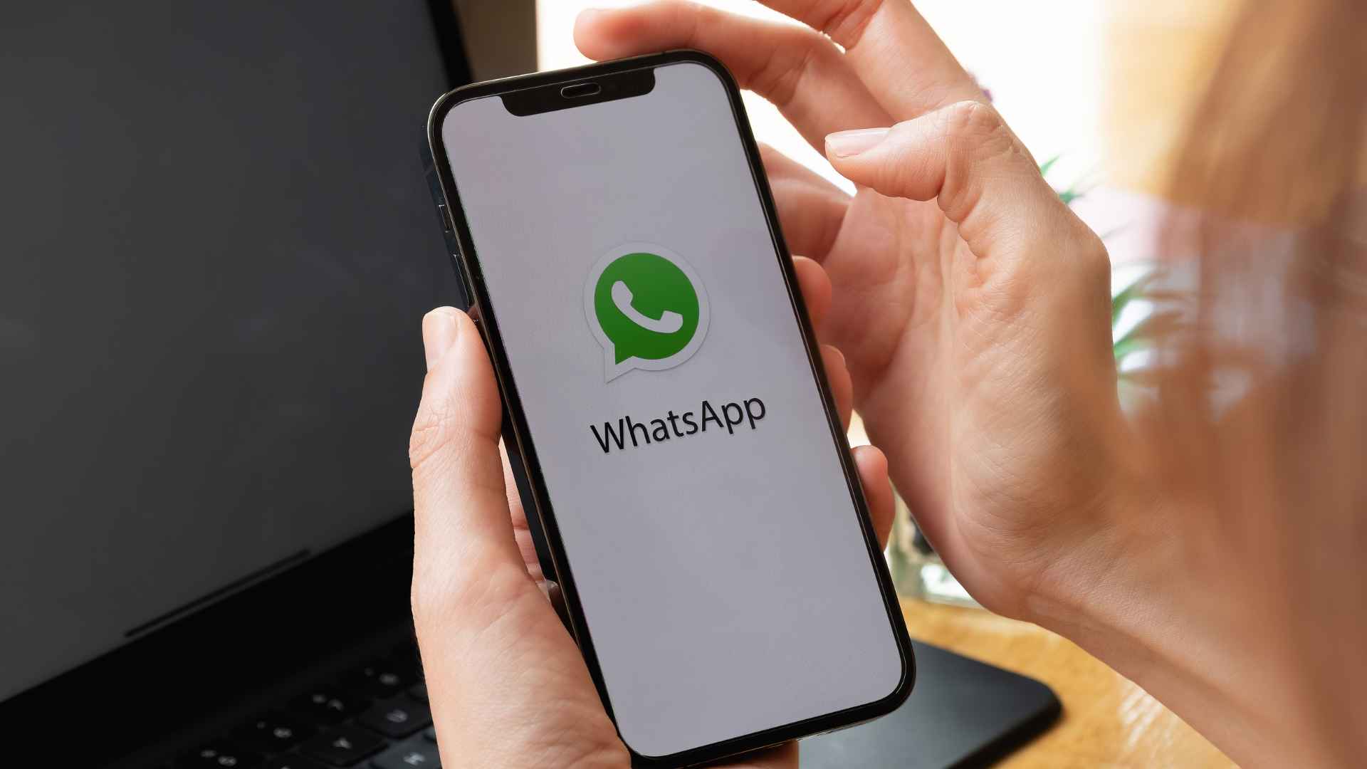 Person holding smartphone with WhatsApp logo before testing the app’s redesigned calling interface that competes with Zoom and Apple FaceTime