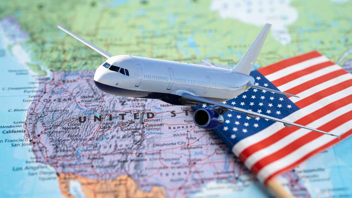 Model airplane on U.S. map beside American flag, symbolizing Americans relocating to Portugal