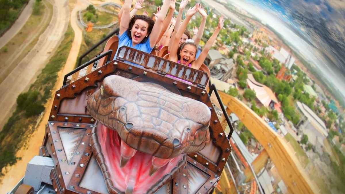 Riders enjoy a thrilling roller coaster ride at an amusement park, highlighting the excitement before park closures.