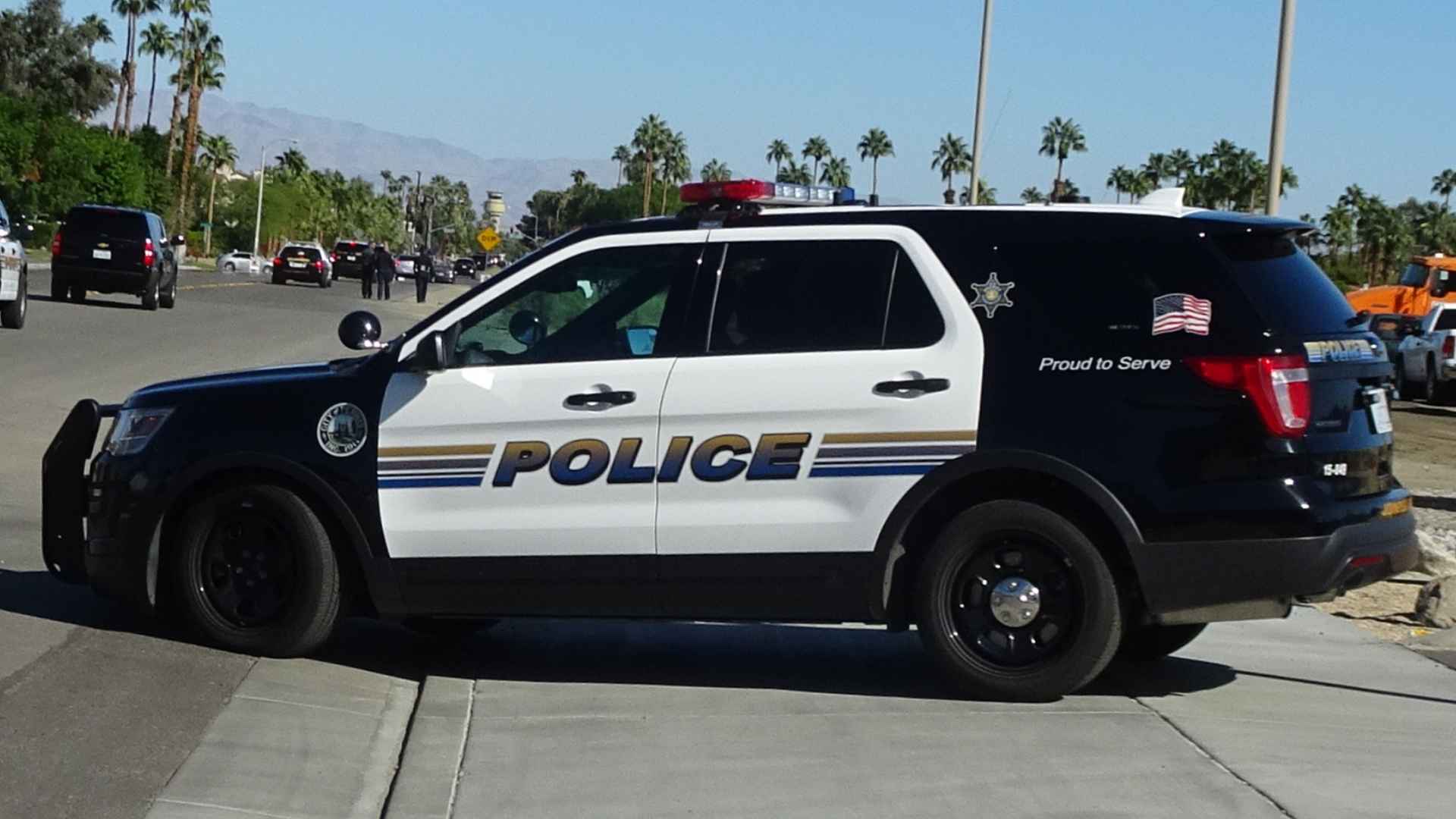 California police SUV on duty during public event in sunny street with palm trees in background