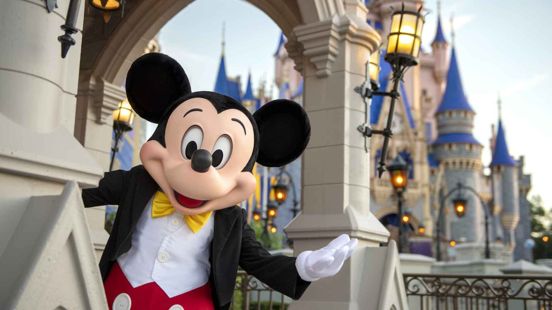 Mickey Mouse waves beside Cinderella Castle at Magic Kingdom as Disney World prepares to close attractions for the upcoming Piston Peak expansion.