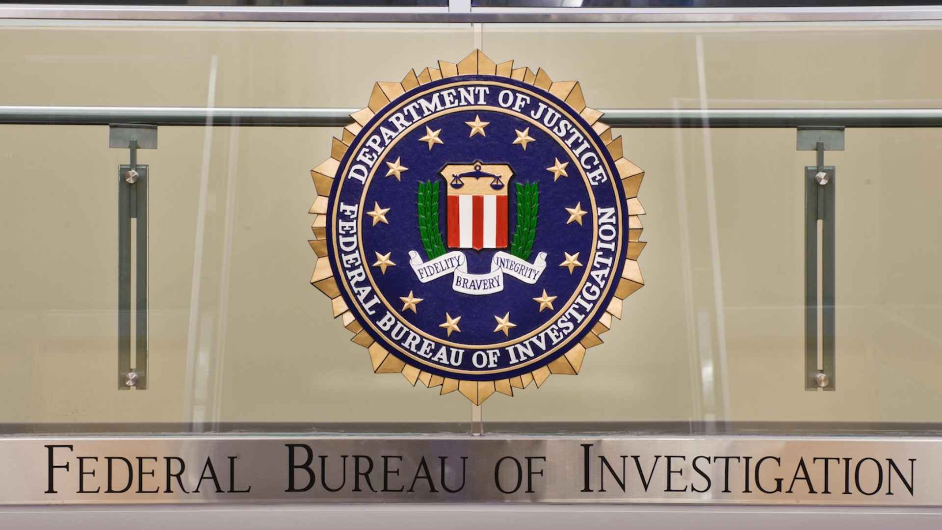 Official FBI emblem at Federal Bureau of Investigation headquarters warning about phone scams stealing financial data