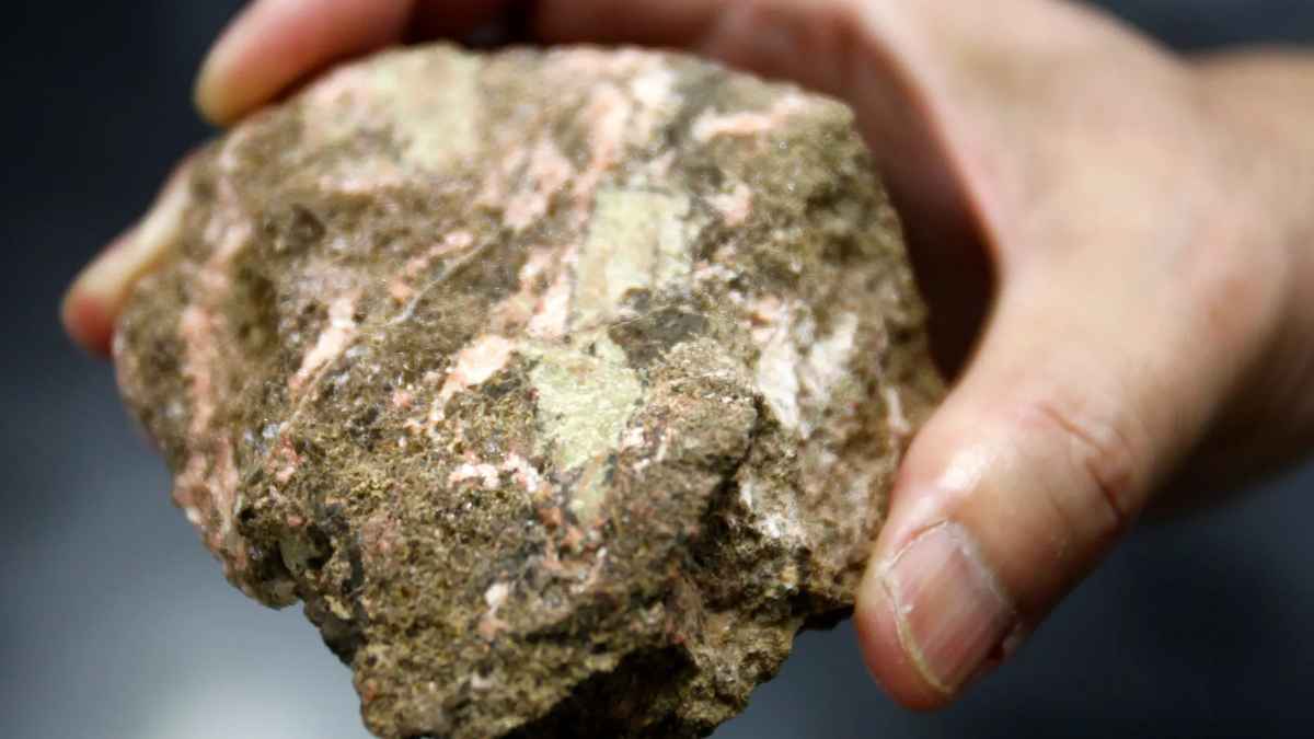 A hand holding a rare earth minerals sample recently discovered beneath a coal mine in Wyoming