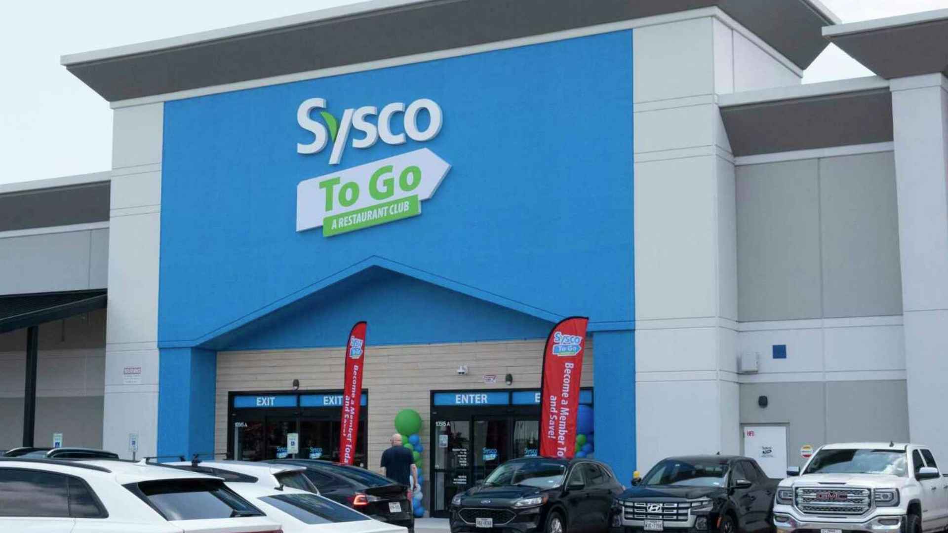 Exterior of Sysco To Go storefront with parked cars, highlighting Sysco’s public presence amid its $2.3 million data-breach settlement.