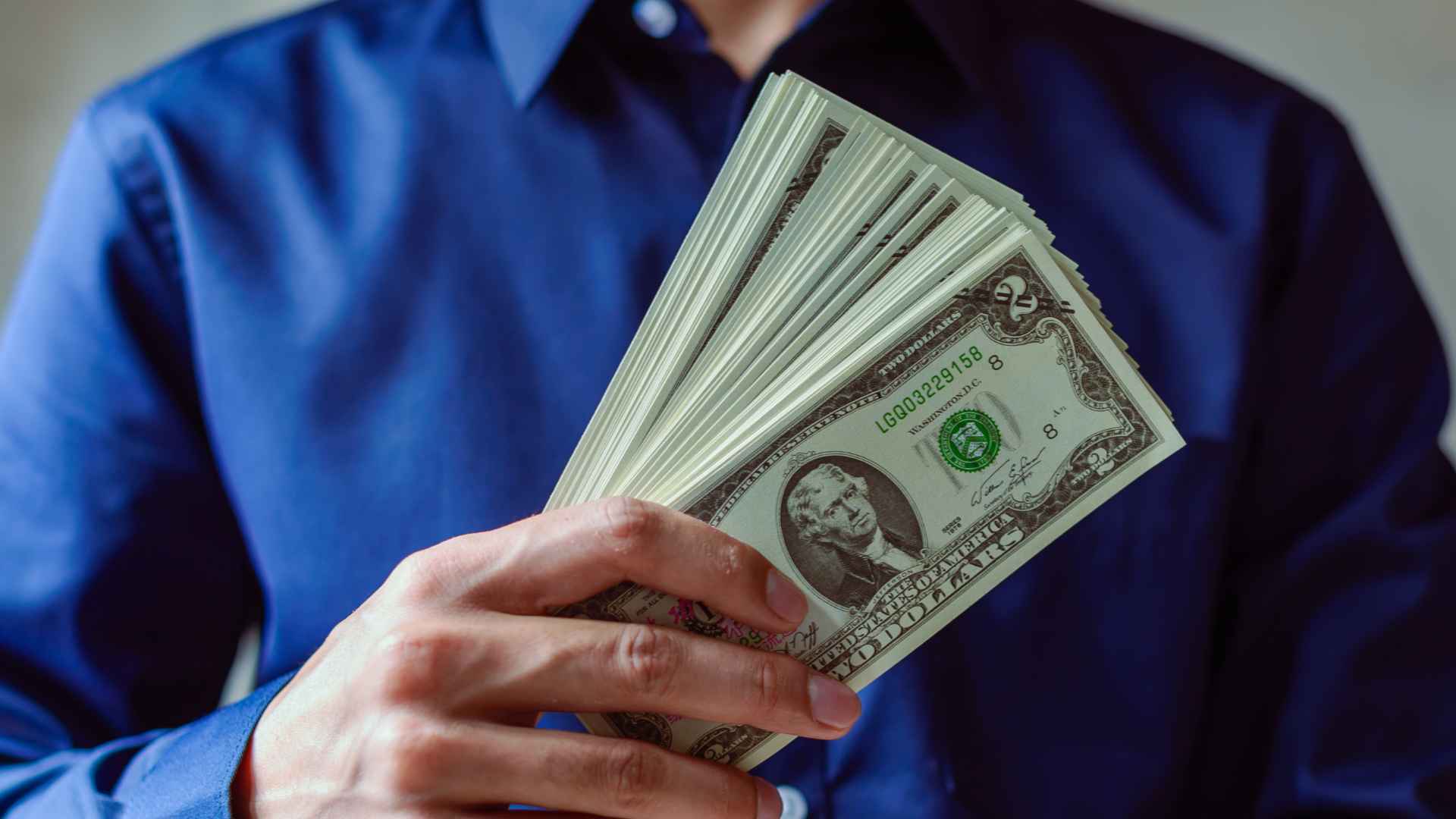 Fan of U.S. dollar bills representing July 9, 2025 Social Security checks after a 2.5 percent COLA boost