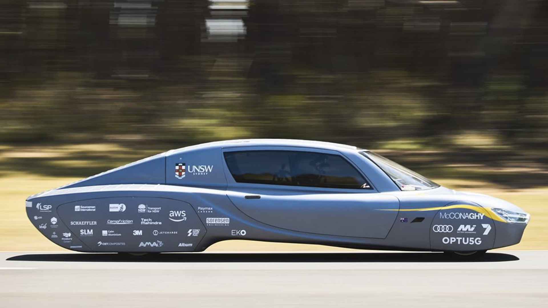 Solar-powered Aptera electric car driving, highlighting aerodynamic design for 1,000-mile range without gas or charging.