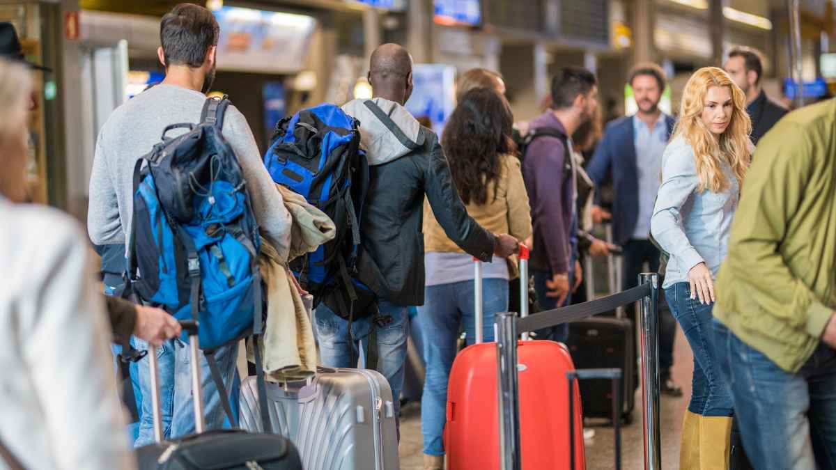 Travelers waiting in long airport security lines, eligible for TSA PreCheck benefits
