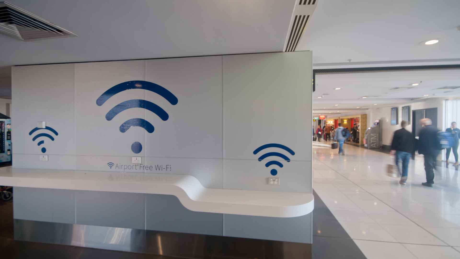 airport free wifi charging station with large wifi symbols and travelers in background