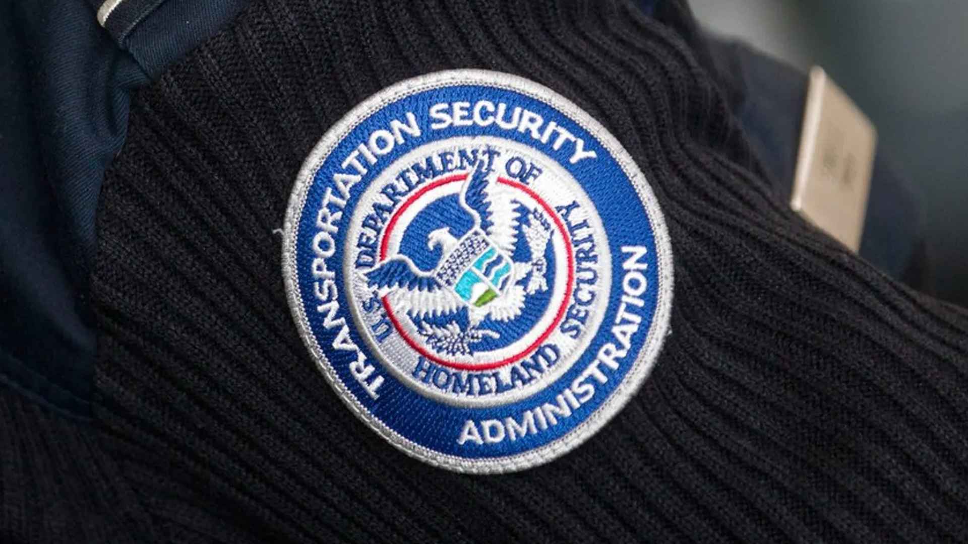 TSA badge on uniform reminding travelers of airport security fines up to $12,900