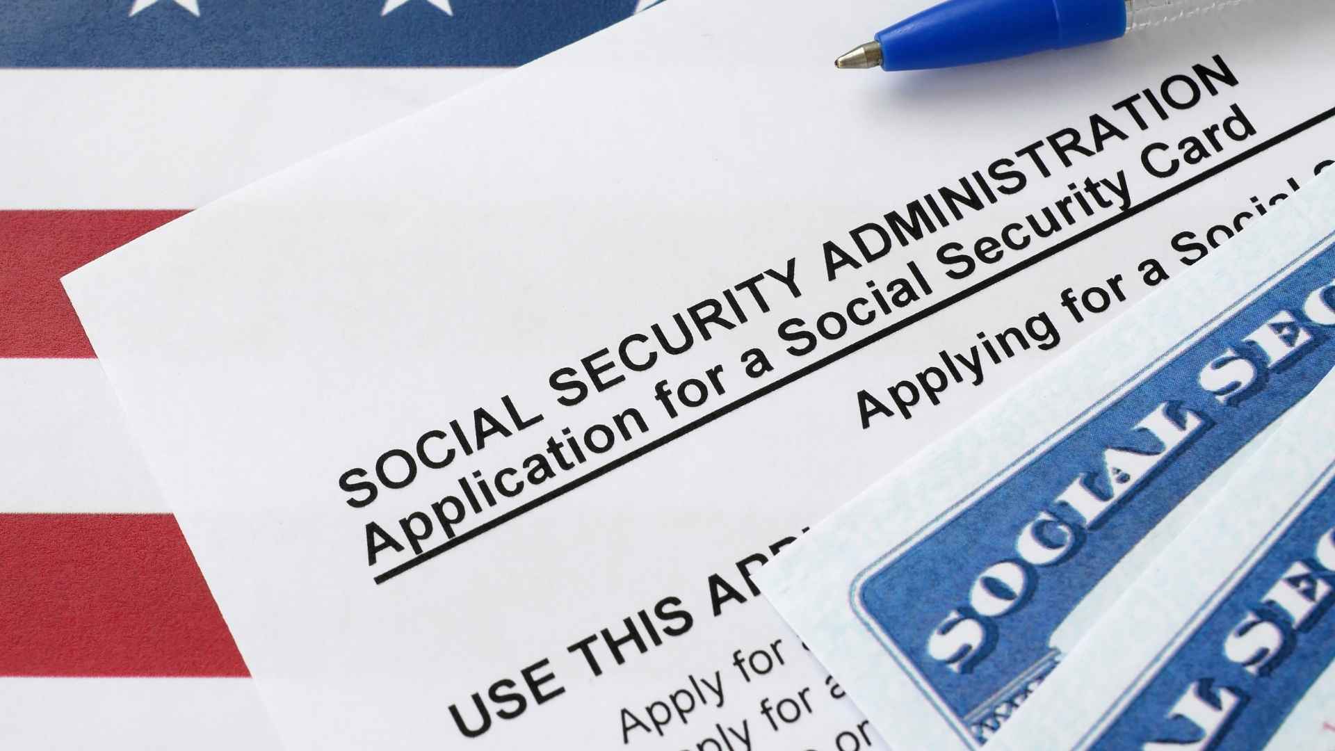 Social Security application form and card on a United States flag, representing stricter phone verification policies