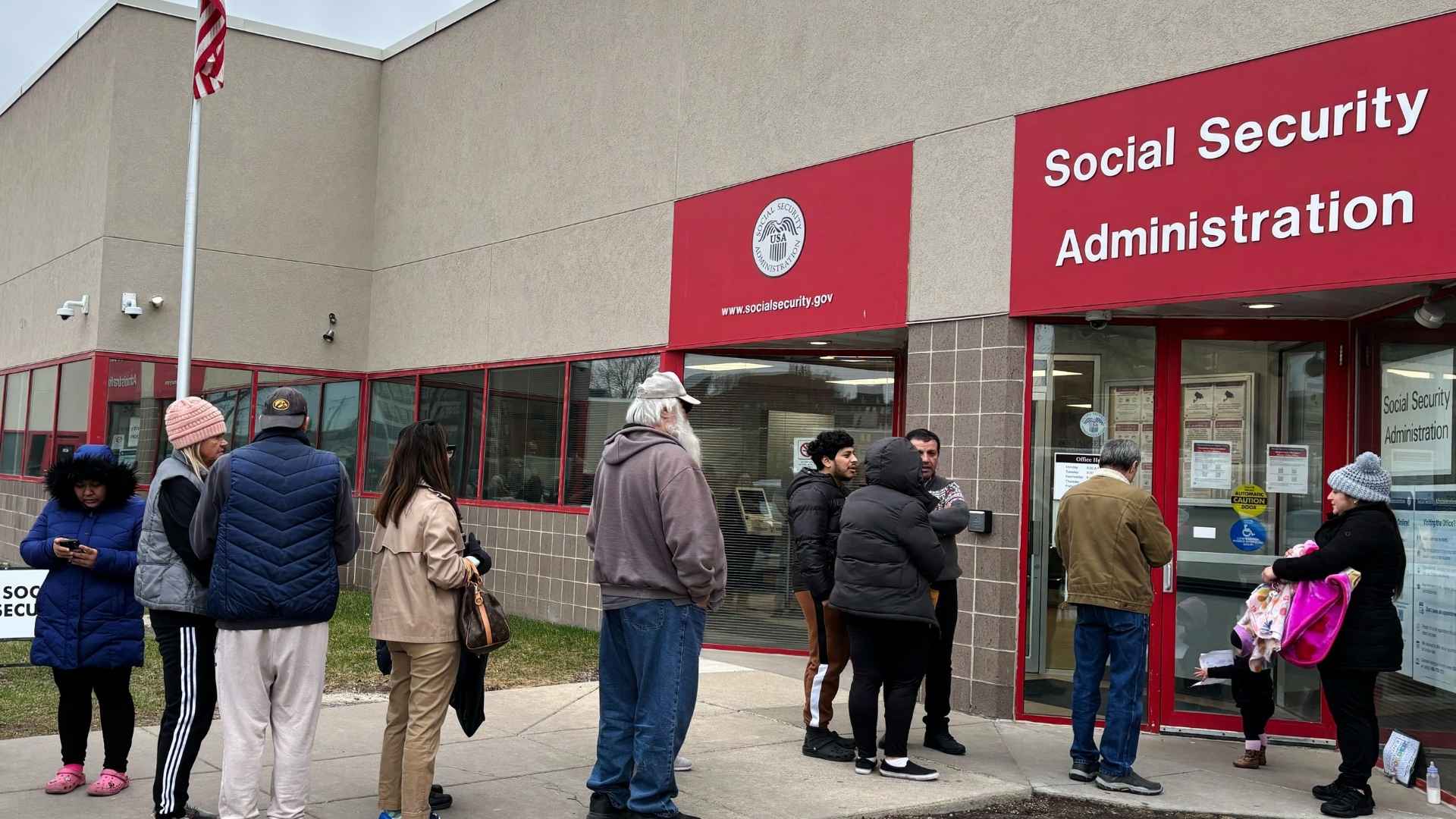 People waiting in long lines outside a Social Security Administration office due to new SSA verification rules
