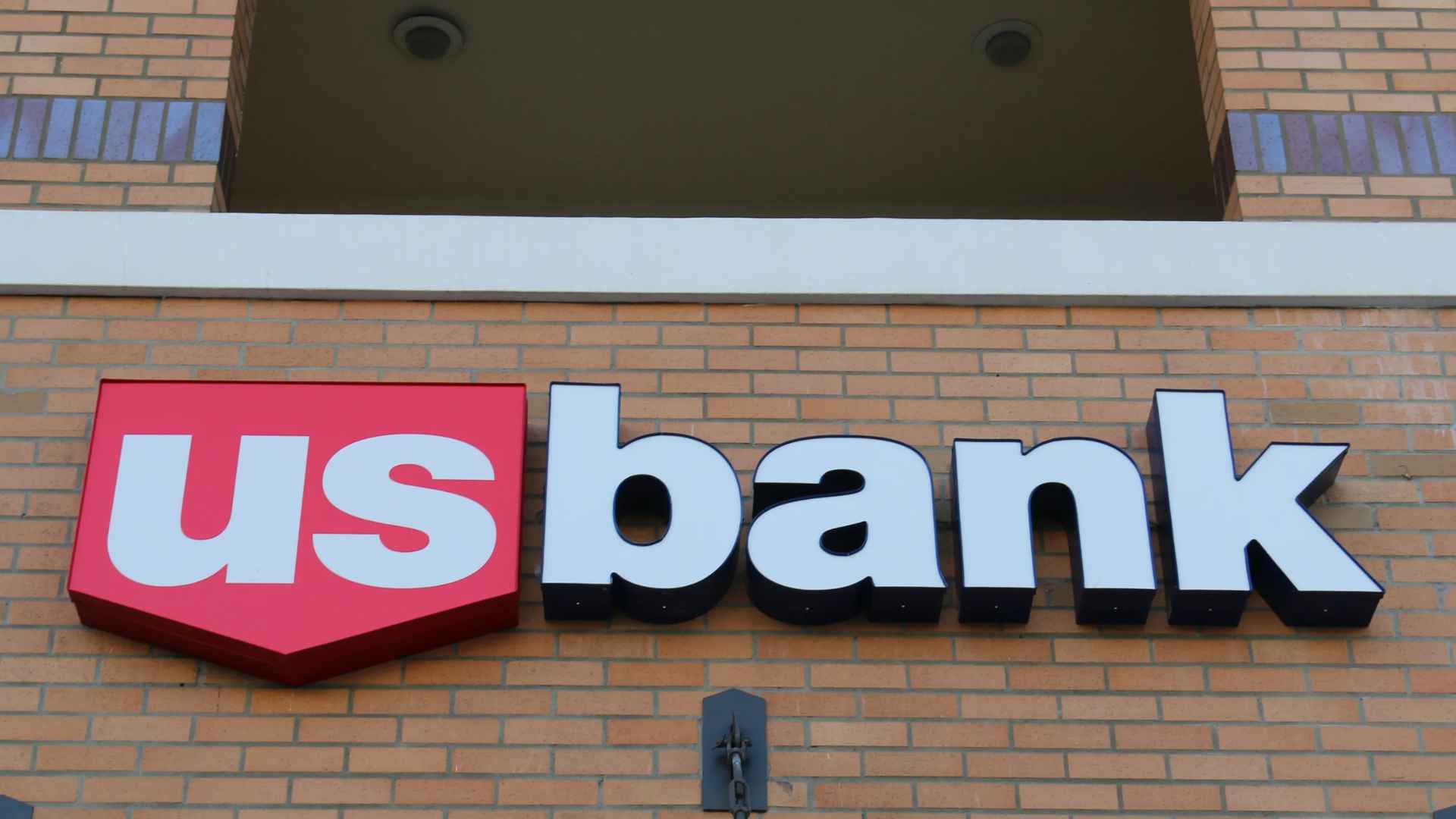 U.S. Bank branch sign on brick building, representing upcoming closure of 40 branches in 17 states.