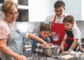 Abuela y niños cocinando juntos en la cocina, representando el rol de amas de casa y el cuidado familiar