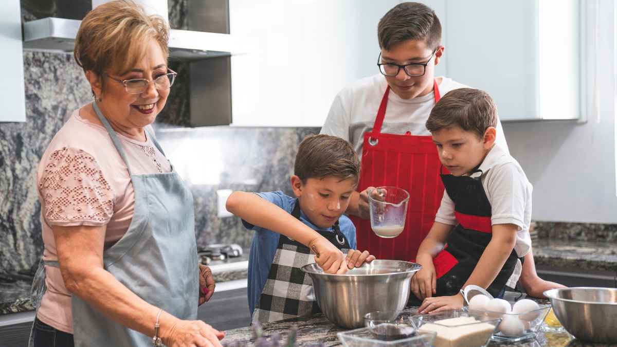 Abuela y niños cocinando juntos en la cocina, representando el rol de amas de casa y el cuidado familiar