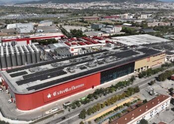 Vista aérea de la fábrica de Estrella Damm en El Prat de Llobregat, España, destacando su planta de producción y depósitos de cerveza