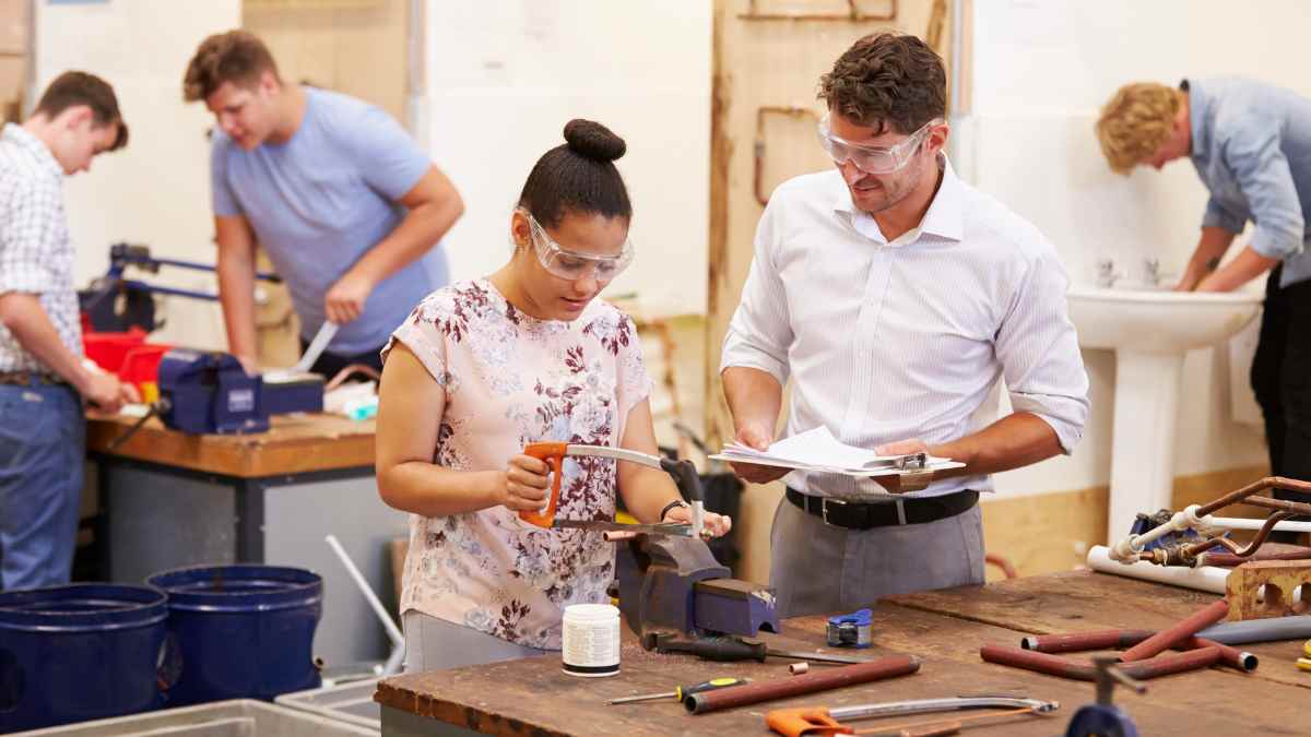 Estudiantes de Formación Profesional en un taller de fontanería con un instructor supervisando el aprendizaje práctico en 2025