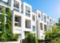 Edificio de apartamentos modernos con áreas verdes y balcones en una zona residencial