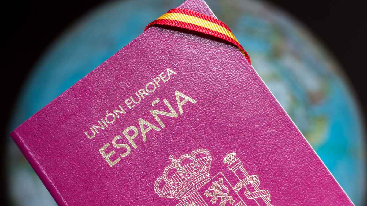 Pasaporte español con cinta de la bandera sobre un globo terráqueo, destacando la nueva fecha del BOE