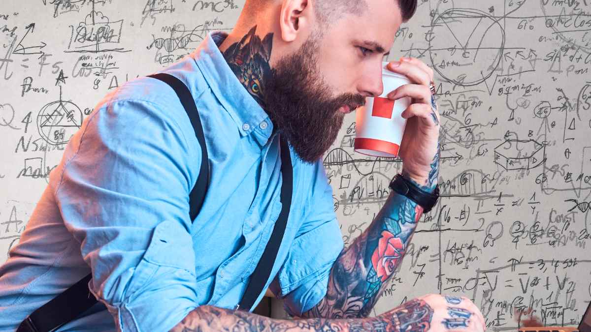 Hombre con tatuajes sosteniendo un café mientras analiza opciones de FP con alta empleabilidad y sueldos de hasta 1.900 euros