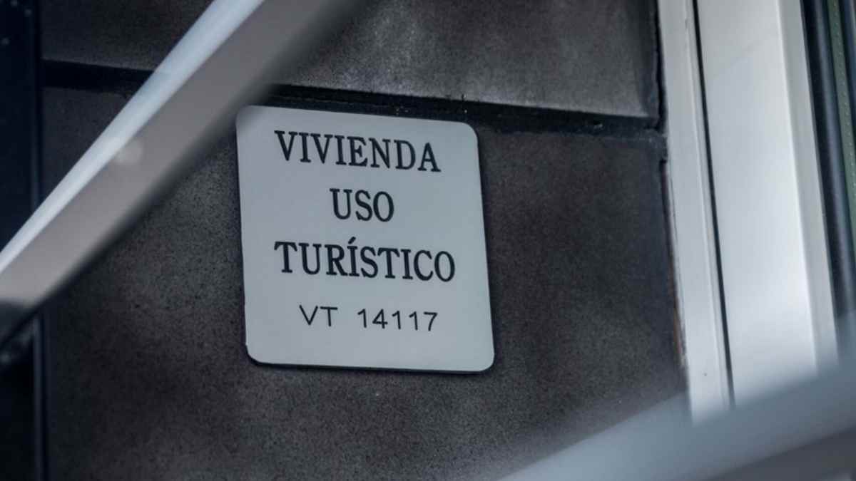 Placa de vivienda de uso turístico con número de registro VT 14117 en un edificio residencial